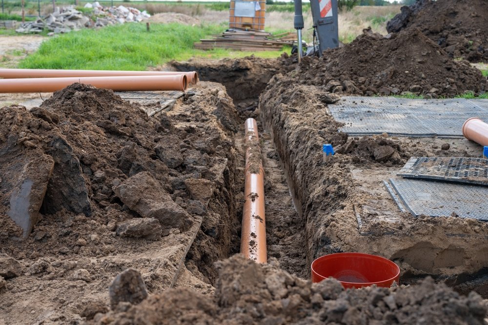 sewer,pipe,installation,in,ground,trench,at,residential,construction,site.